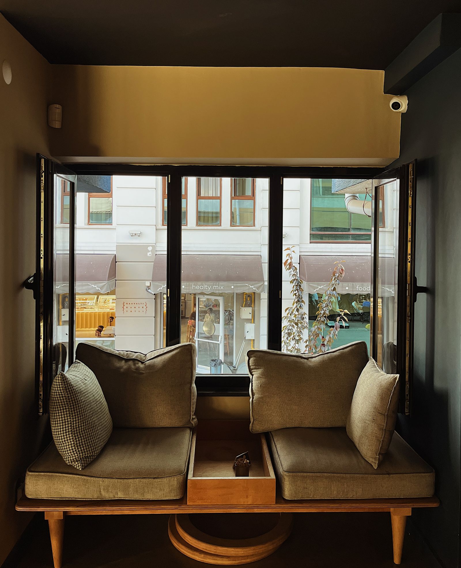A window-side cafe seat with cushions in warm afternoon light